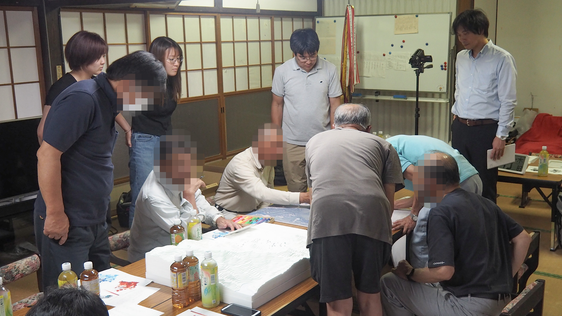 地区の立体模型と航空写真を囲んで座談会を行う様子
